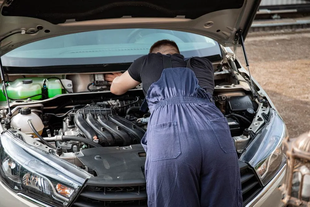 Technician assisting with a broken-down car during roadside recovery