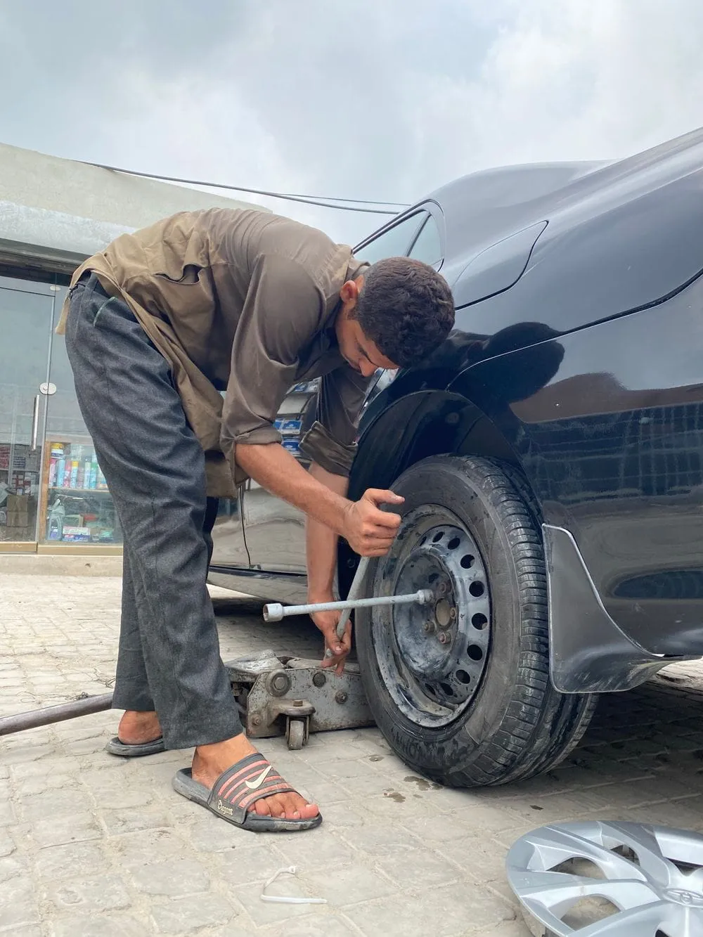 Roadside technician changing a flat car tyre