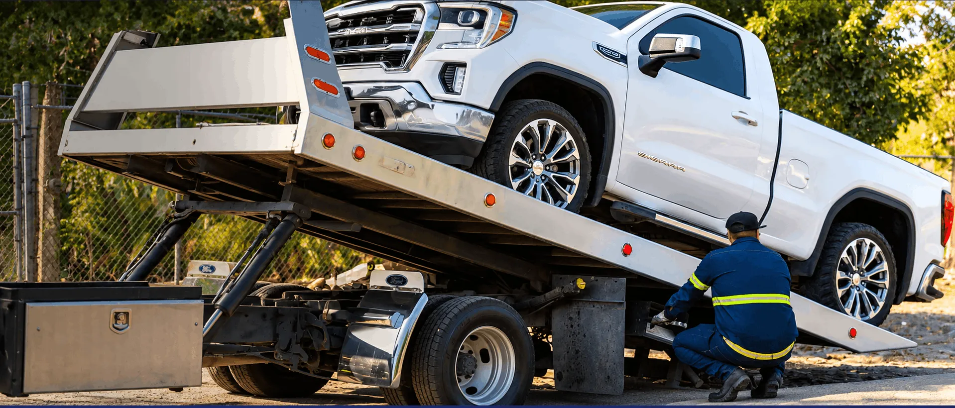Tow truck transporting a vehicle on a flatbed recovery truck
